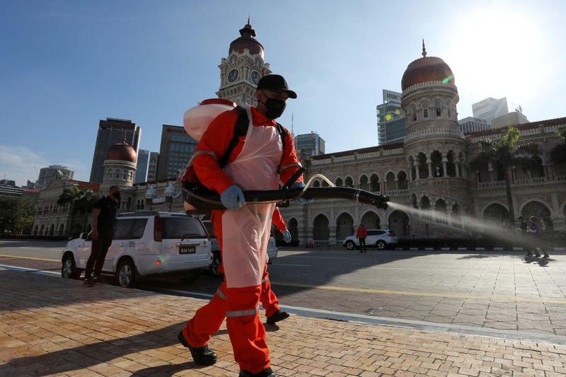 FILE PHOTO: A worker sprays disinfectant at Independence Square during