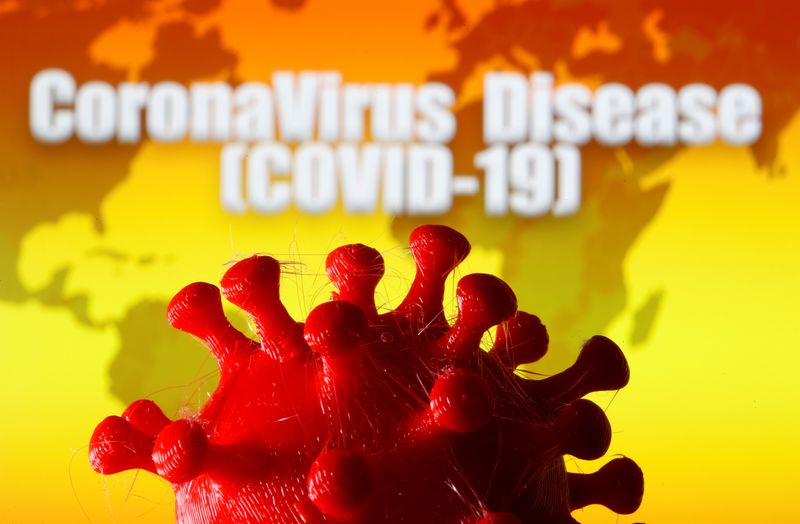 A 3D-printed coronavirus model is seen in front of a