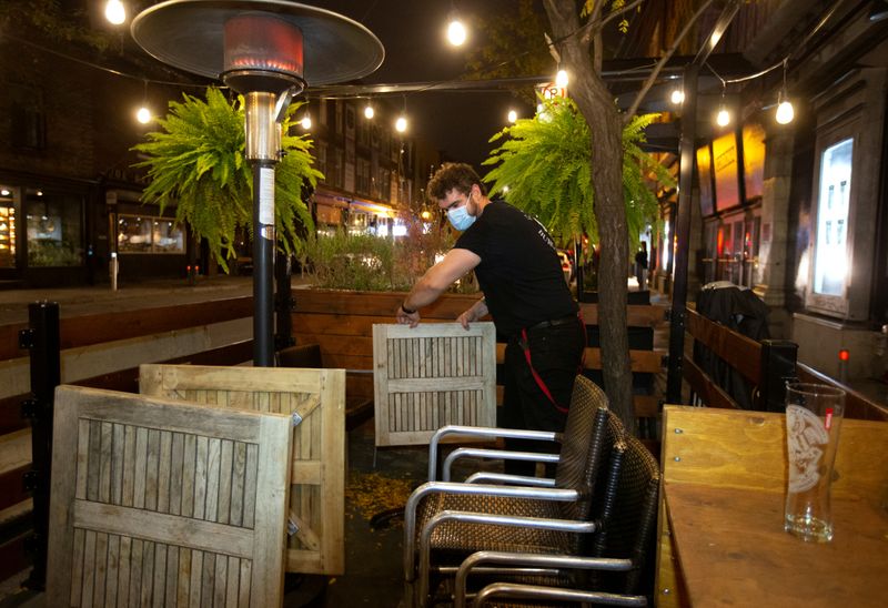Employee dismantles the terrasse at closing time in Montreal