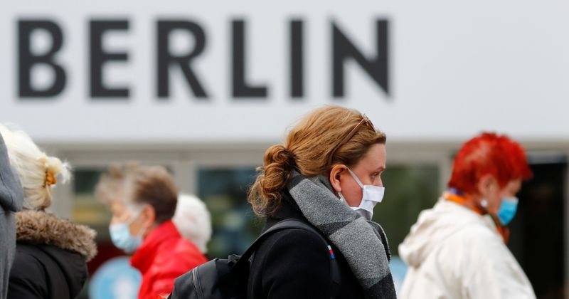 People wearing face masks are pictured at Schloss Strasse shopping