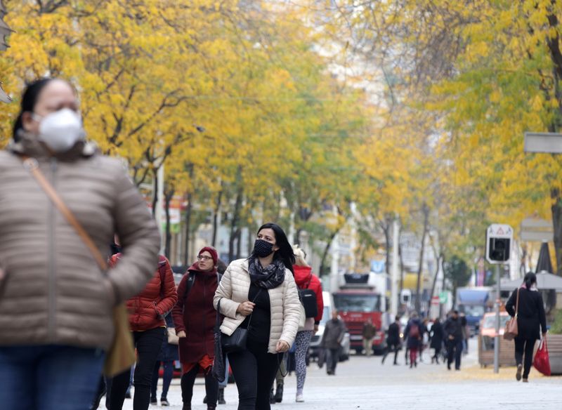 People walk along a shopping street in Vienna