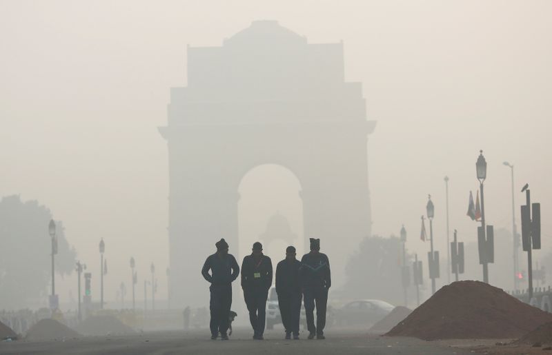 FILE PHOTO: Men walk in front of the India Gate