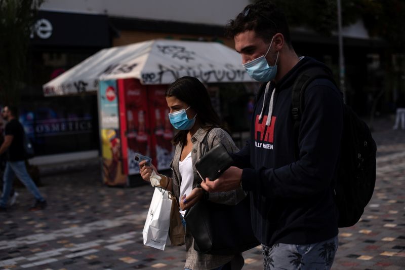 People wearing protective face masks make their way in Monastiraki