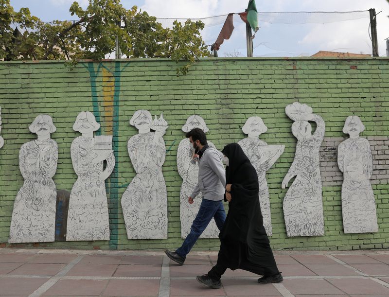 FILE PHOTO: Iranians wearing face masks walk on a street