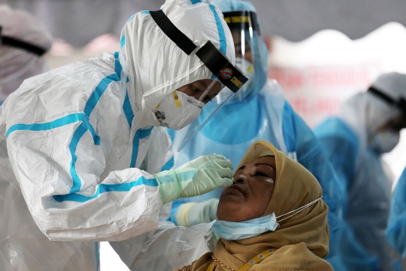 Medical worker collects a swab sample from a woman to