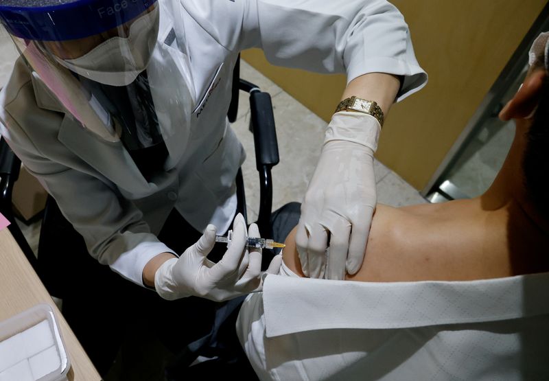 FILE PHOTO: A man gets an influenza vaccine at a