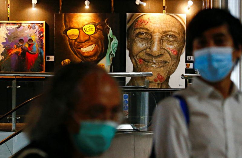 FILE PHOTO: Visitors wearing protective face masks walk past painted