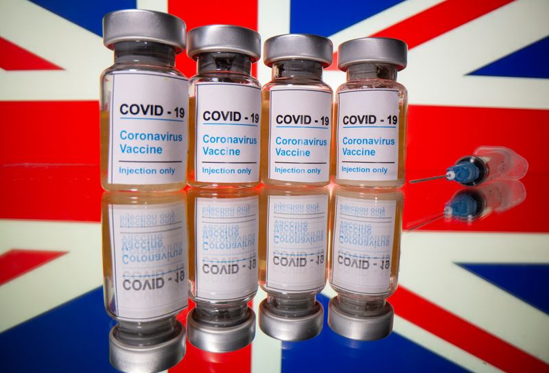Vials and medical syringe are seen in front of British