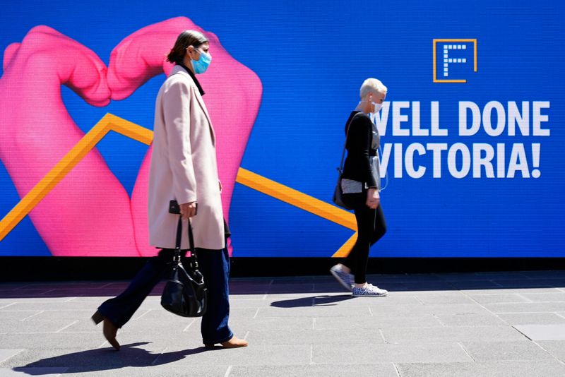 People walk past a ‘Well Done Victoria’ sign after coronavirus