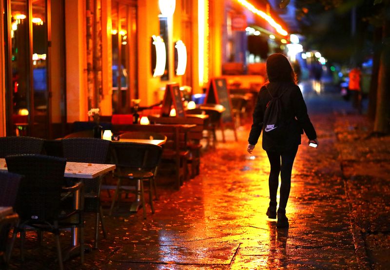 FILE PHOTO: A woman passes empty tables before the late-night