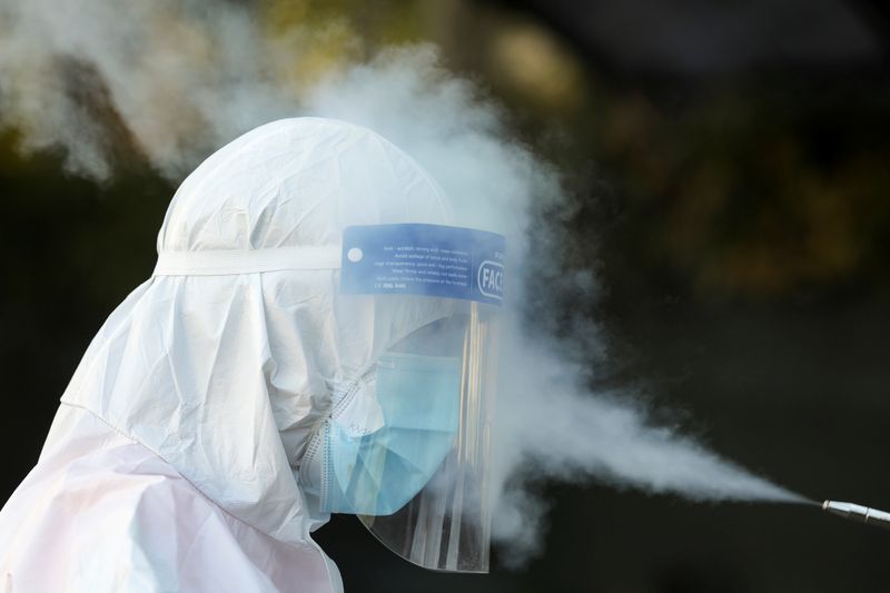 FILE PHOTO: An ambulance worker goes through a disinfection routine