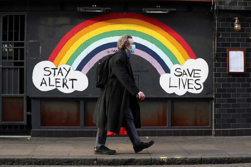 FILE PHOTO: A pedestrian walks past street art in Soho