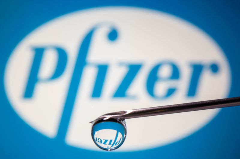 Pfizer’s logo is reflected in a drop on a syringe