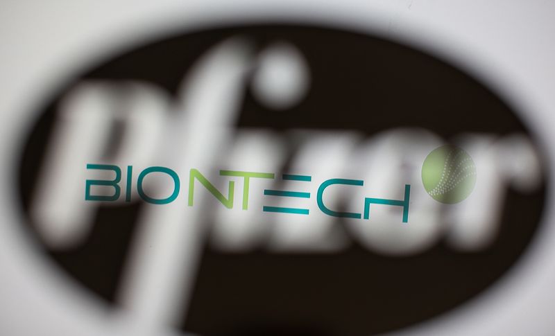 Biontech’s logo is seen through a 3D-printed Pfizer logo in