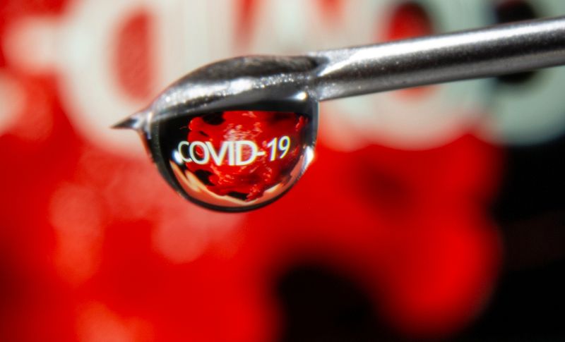 The word “COVID-19” is reflected in a drop on a