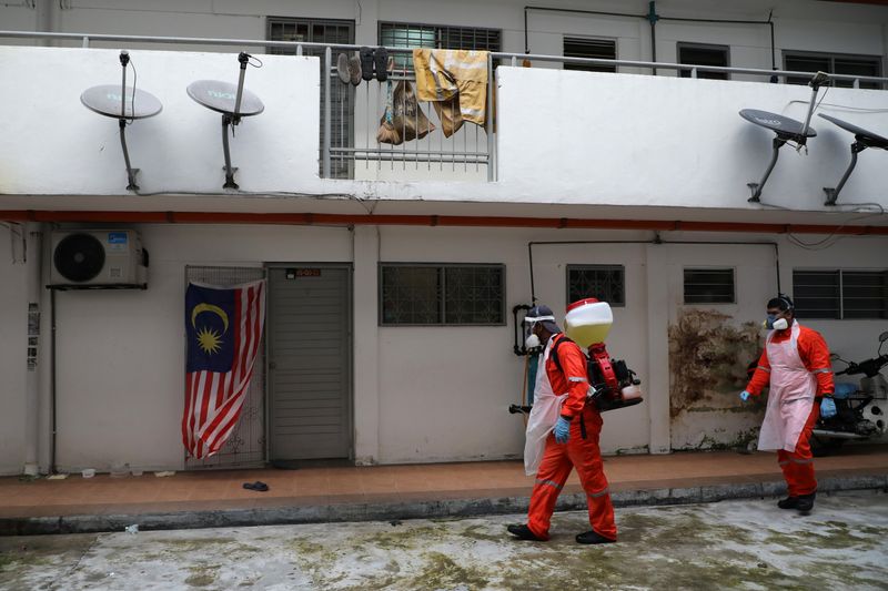 Workers spray disinfectant at an apartment, amid the coronavirus disease