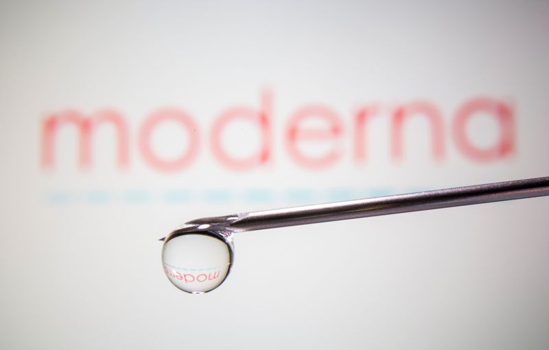 Moderna’s logo is reflected in a drop on a syringe