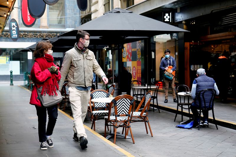 FILE PHOTO:  People walk past a cafe after the