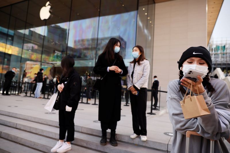 FILE PHOTO: People stand in front an Apple store in