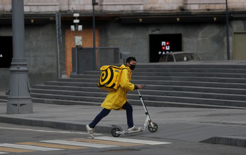 FILE PHOTO: A Yandex.Eats food delivery courier rides a scooter
