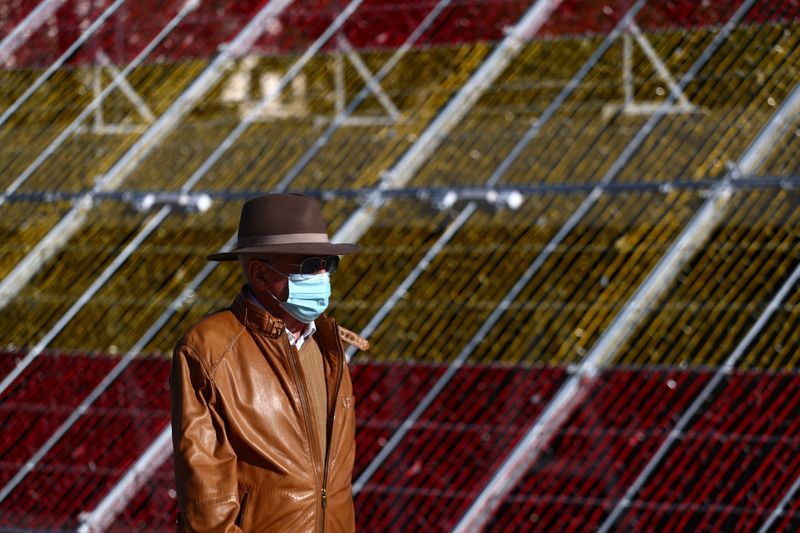 A man wearing a single-use protective mask walks past a