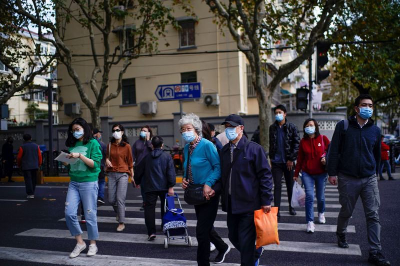 People wearing face masks are seen on a street amid