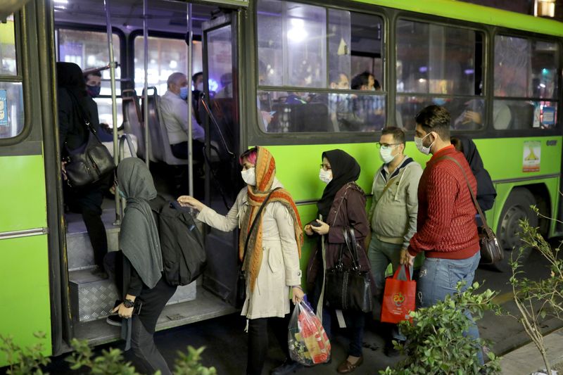 FILE PHOTO: Iranian People wearing protective masks as they board