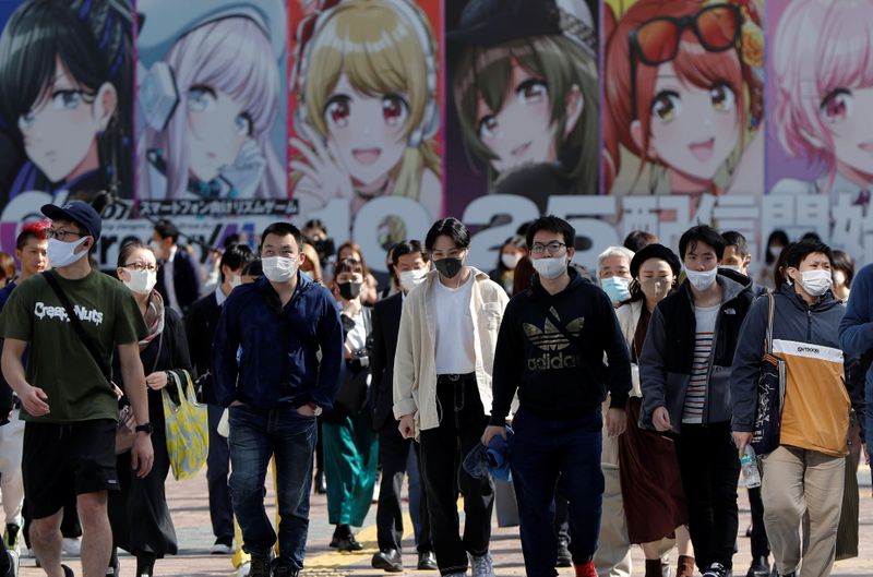FILE PHOTO: People wearing protective face masks walk on the