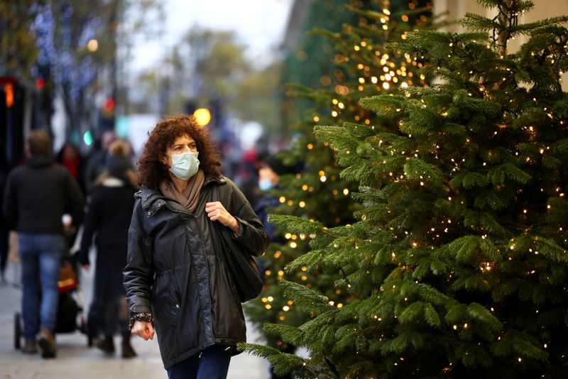 FILE PHOTO: A woman walks past Christmas trees on Oxford