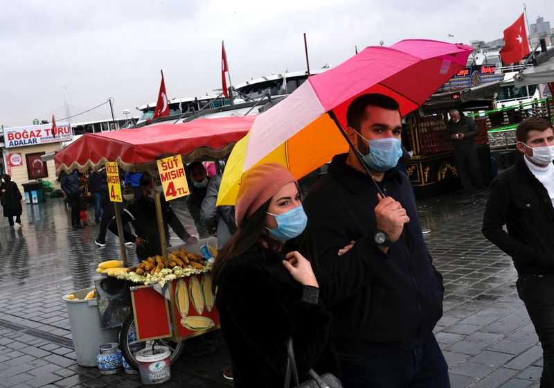 People wearing protective masks stroll in Eminonu district in Istanbul