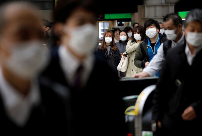 Passengers wearing protective face masks, following an outbreak of the