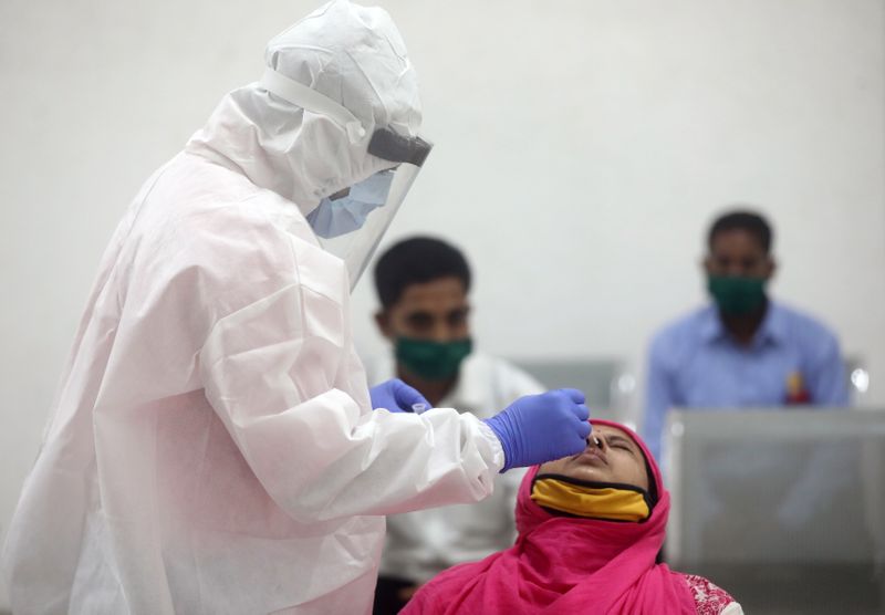 A health worker in a personal protective equipment (PPE) collects