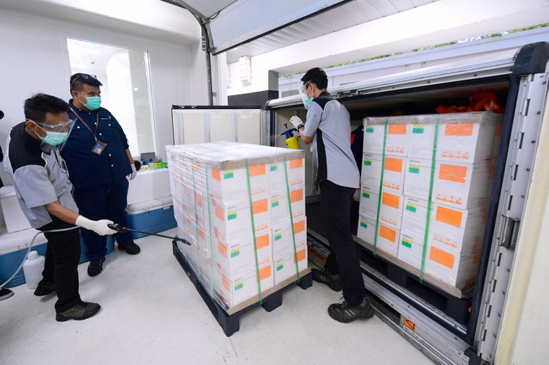 Officials spray disinfectant to coronavirus disease (COVID-19) vaccines from China’s