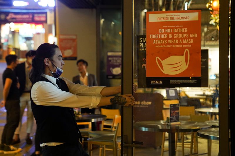 A man pulls the door of a bar in Hong