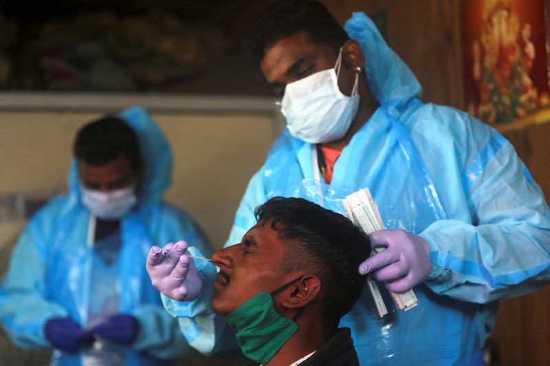 Health worker collects a swab sample from a man during