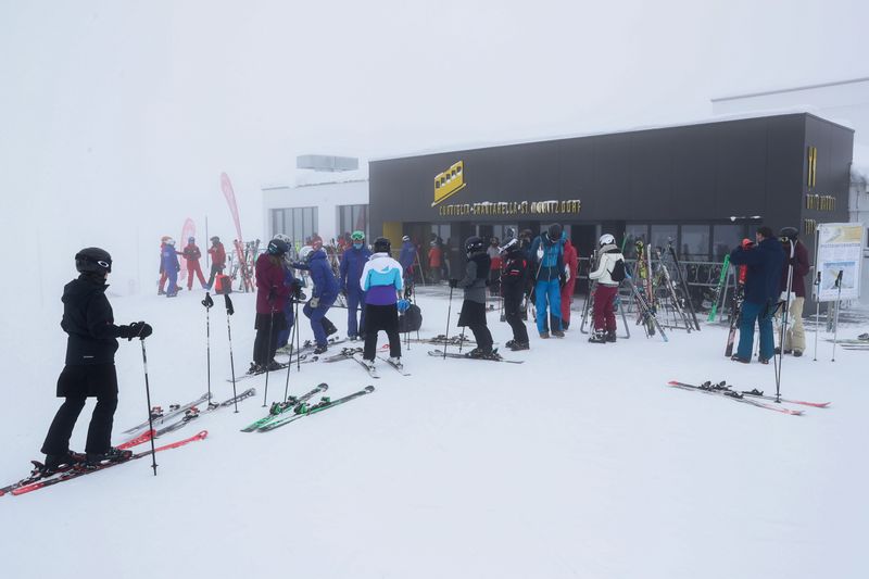 Skiers are seen during foggy weather at the Corviglia ski