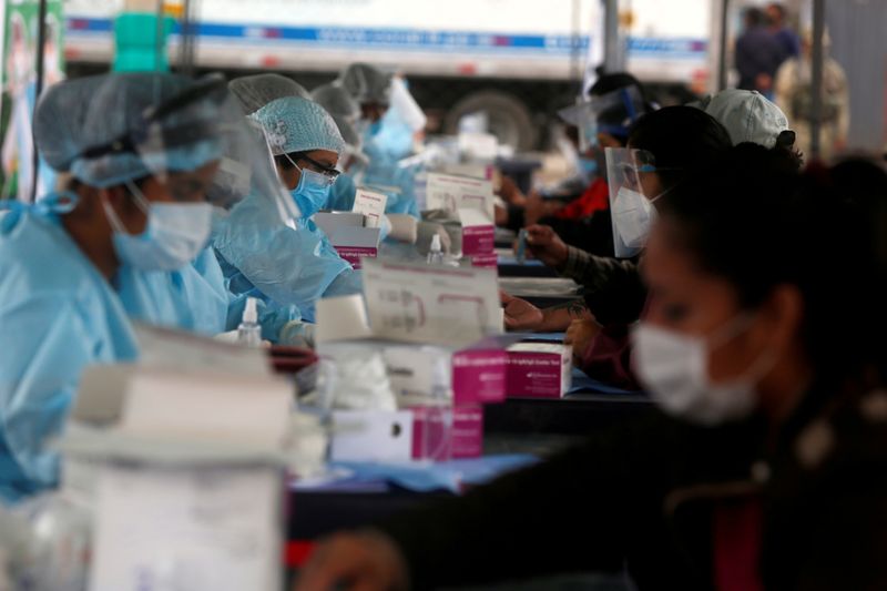 FILE PHOTO: Healthcare workers collect blood samples at COVID-19 testing