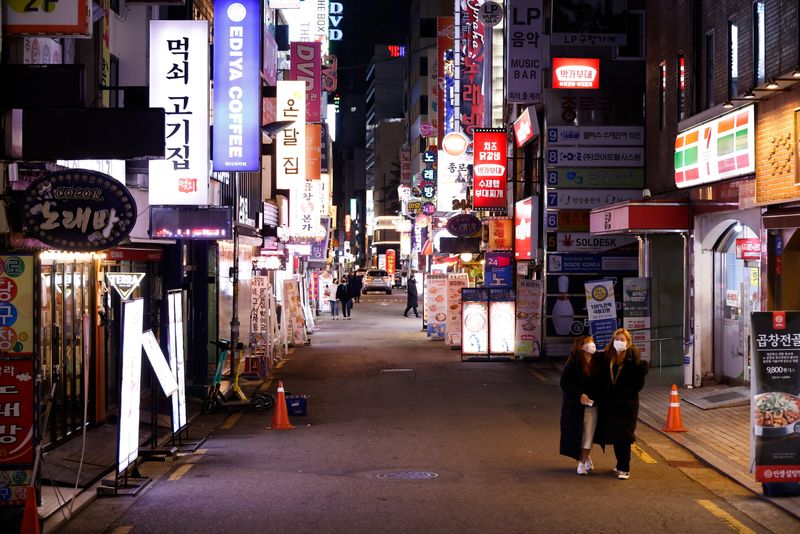 Women walk on an empty street affected by heightened social