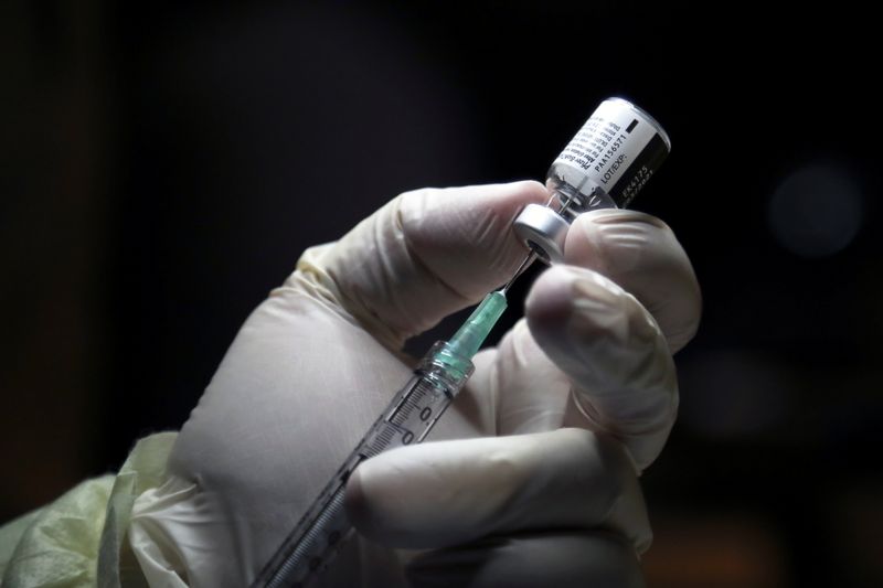 A healthcare worker prepares to administer a Pfizer coronavirus disease
