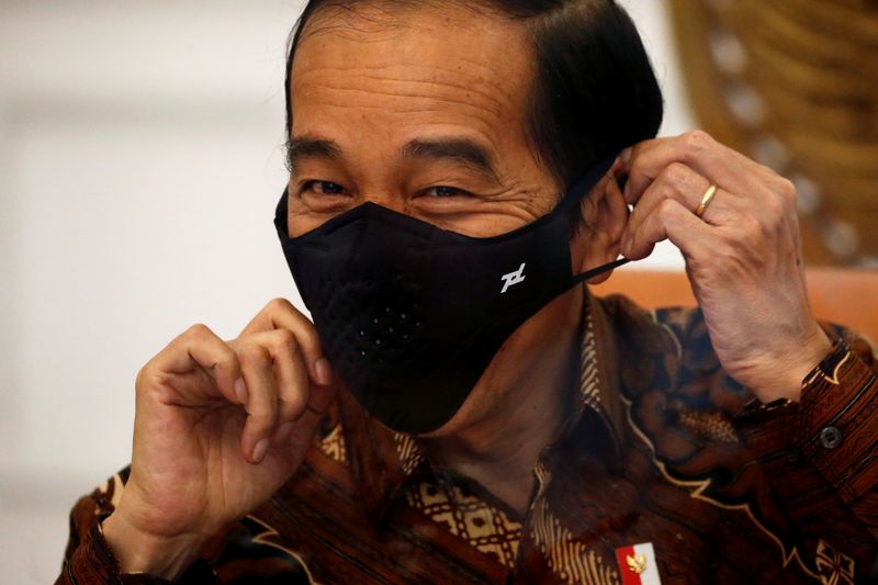 FILE PHOTO: Indonesian President Joko Widodo reacts as he wears