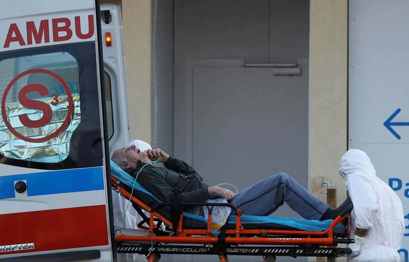 FILE PHOTO: A paramedic transports a COVID-19 patient at a