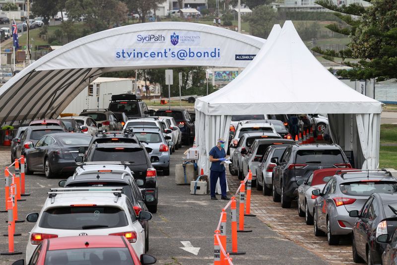 FILE PHOTO: Vehicles queue as medical personnel administer tests at