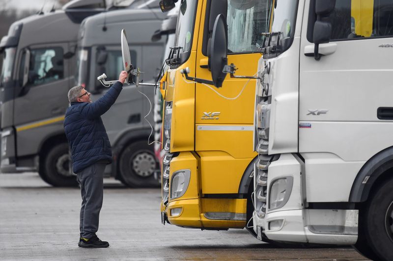 A Hungarian truck driver adjusts a satellite dish for viewing