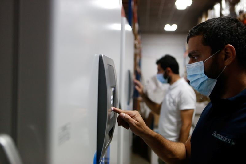 FILE PHOTO: Men inspect a special refrigerator for storing the
