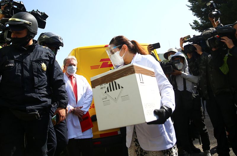 A medical staff member holds a box while simulating to