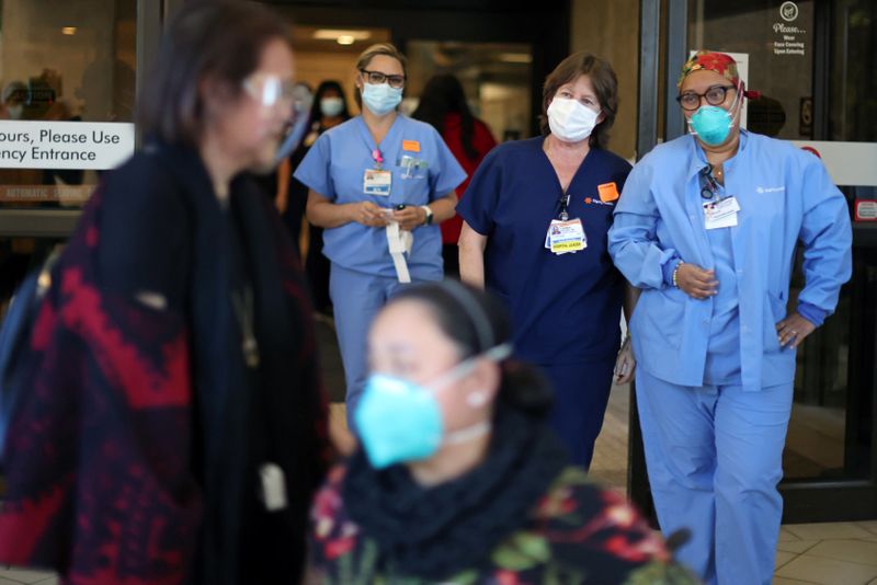 Hospital staff watch Intensive Care Unit Nurse Merlin Pambuan, walk