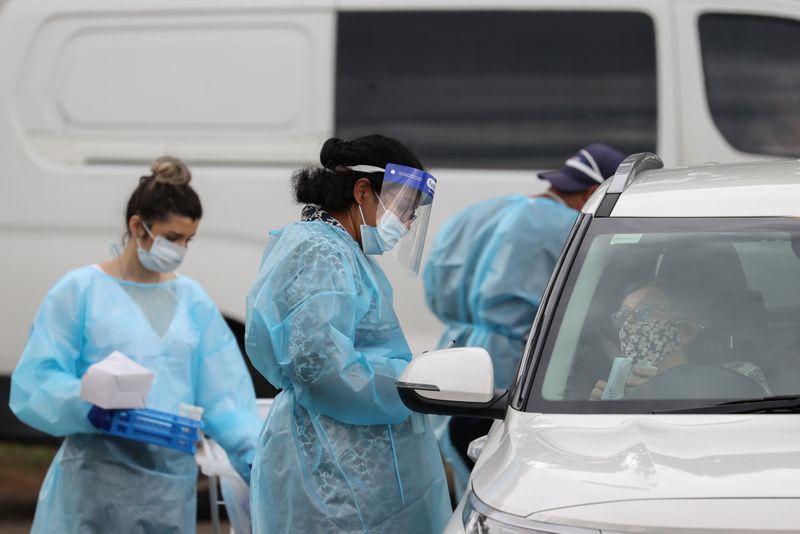 FILE PHOTO:  Medical professionals work at a drive-through coronavirus
