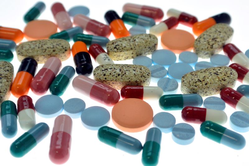 Pharmaceutical tablets and capsules are arranged on table in photo