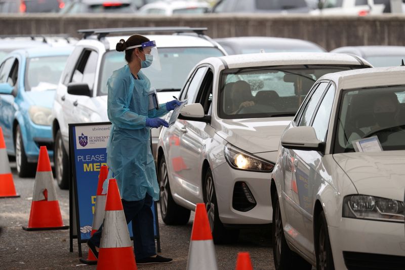 FILE PHOTO:  Vehicles queue as medical personnel administer tests