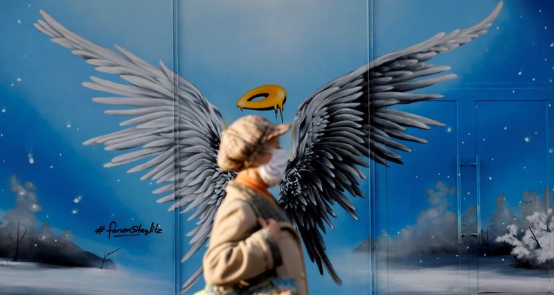 A pedestrian walks past Christmas-themed graffiti in Berlin